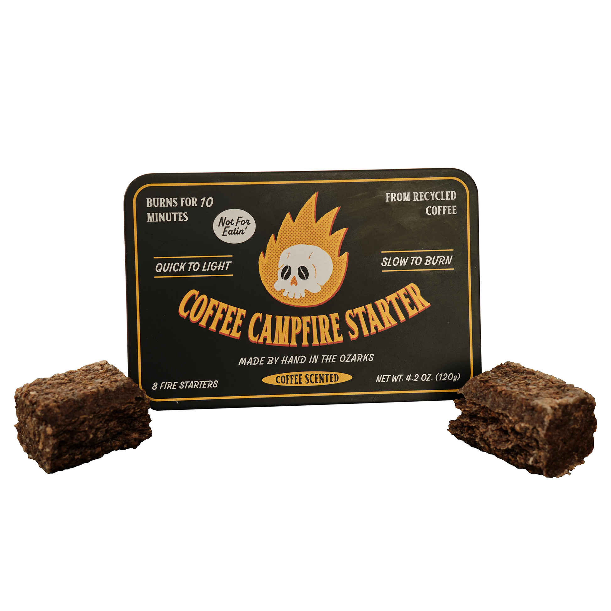 A tin packaging of Coffee Campfire Starter with two briquettes placed in front. The label indicates that it is made from recycled coffee and organic beeswax, and is eco-friendly. Eco friendly fire starters for camping  and grilling made from coffee husks, waterproof fire starter for fire pit and charcoal grill